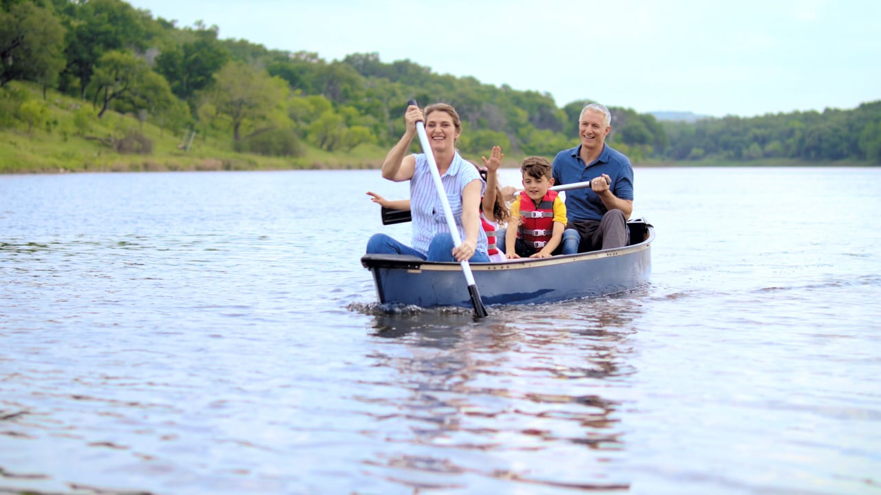 A family paddling a canoe in the Greater Texas Credit Union Freedom commercial